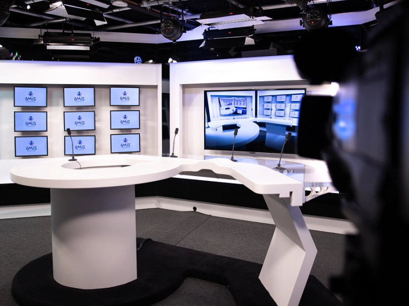Studio d'entraînement professionnel avec décor télé et caméras pour les exercices pratiques des étudiants en média