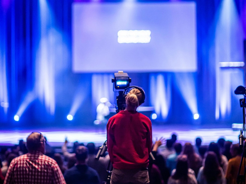 Réalisatrice TV face à une scène de conférence